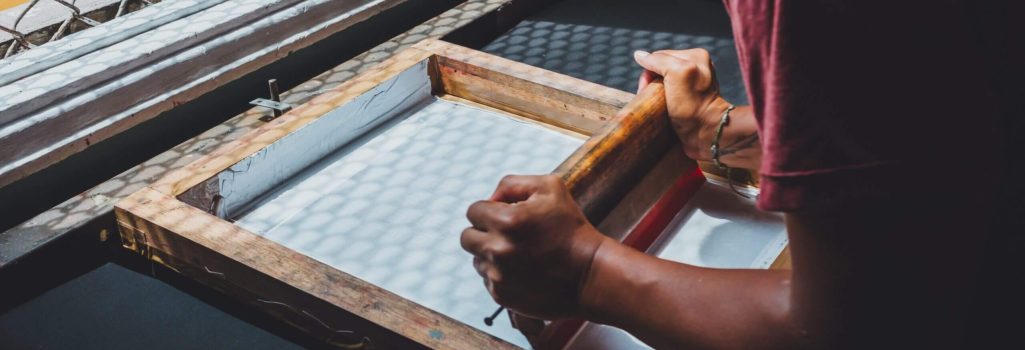 A person is working on an object in front of a window.