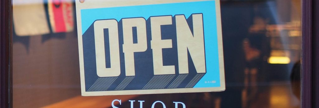 A sign that says open and the word shop.